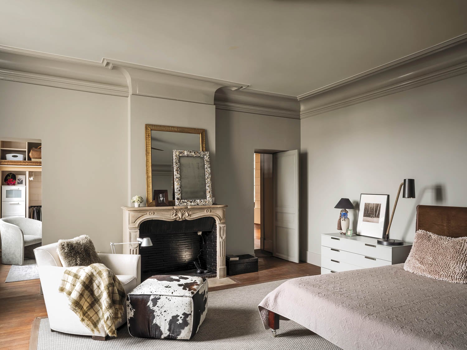 bedroom with fireplace and hide-covered ottoman
