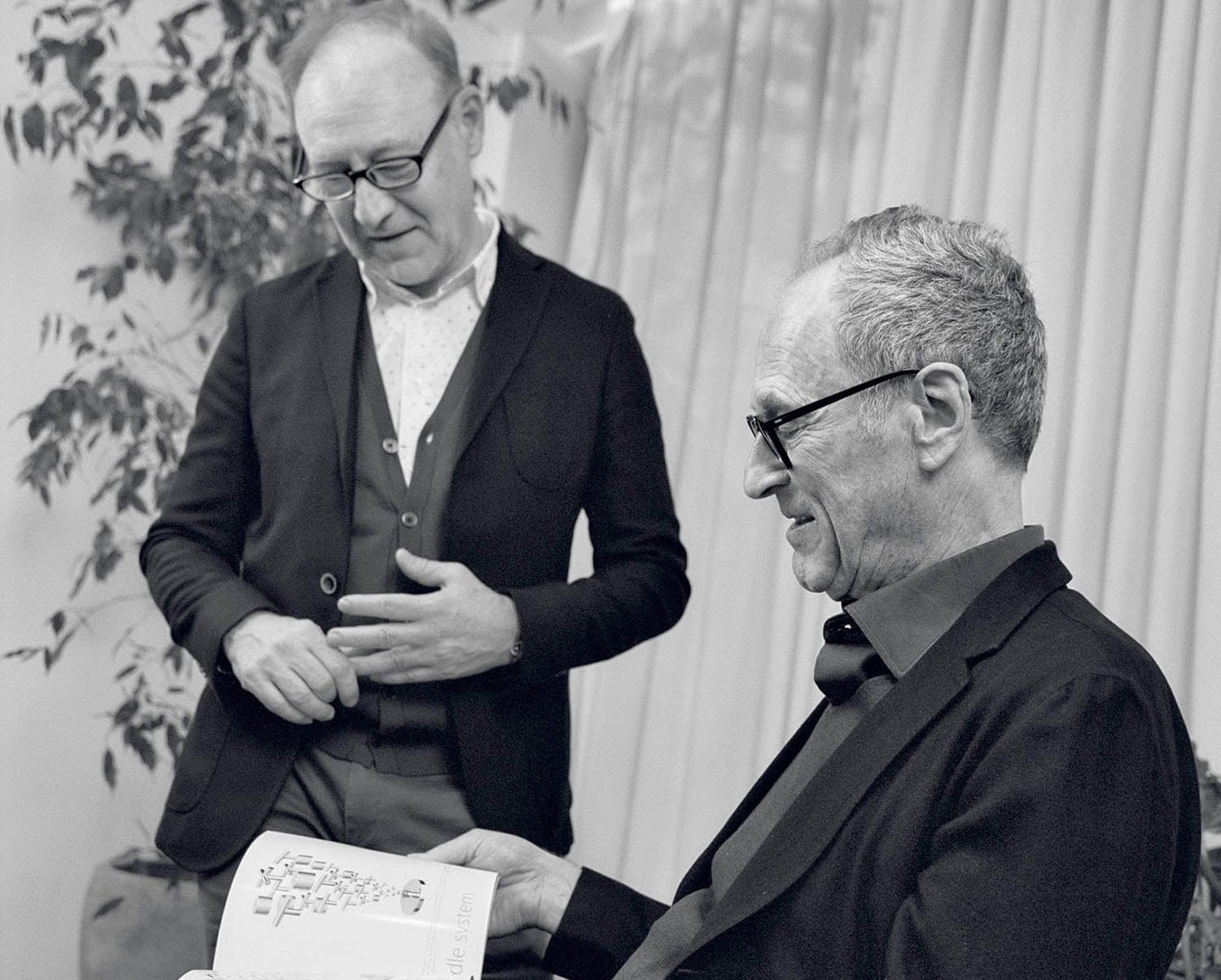 A man in a suit and tie is looking at a piece of paper.