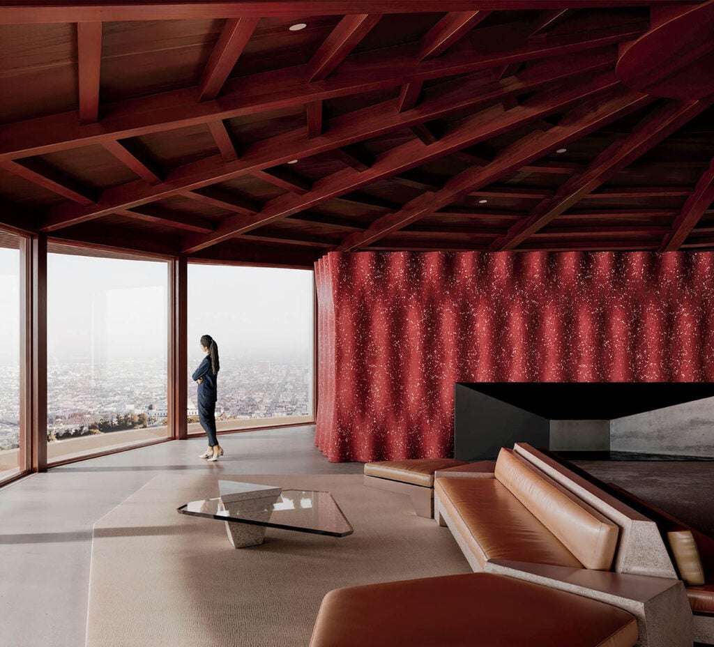 A man standing in a living room with a view of a city.