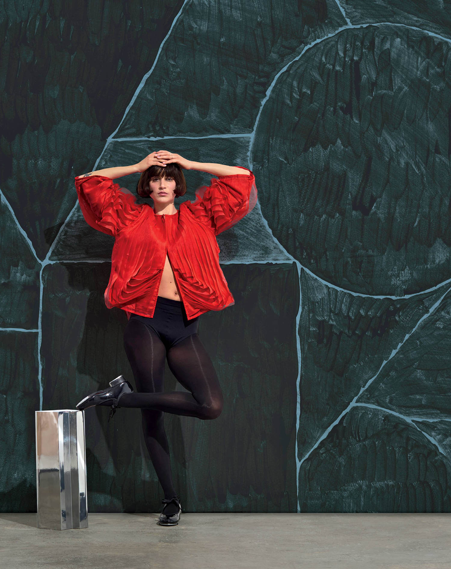 A woman in a red shirt and black tights.