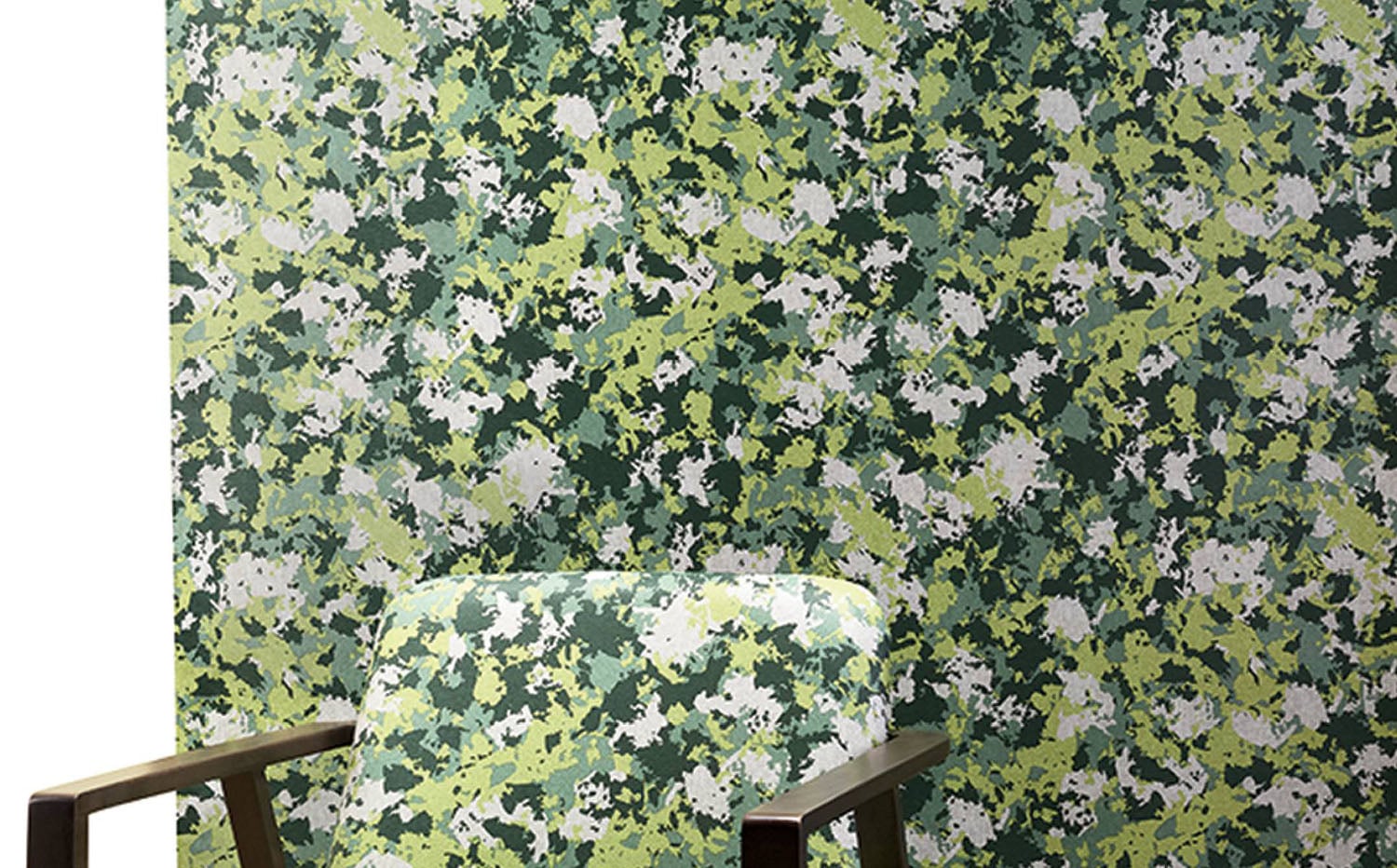 A chair sitting in front of a wall with green and white paint.