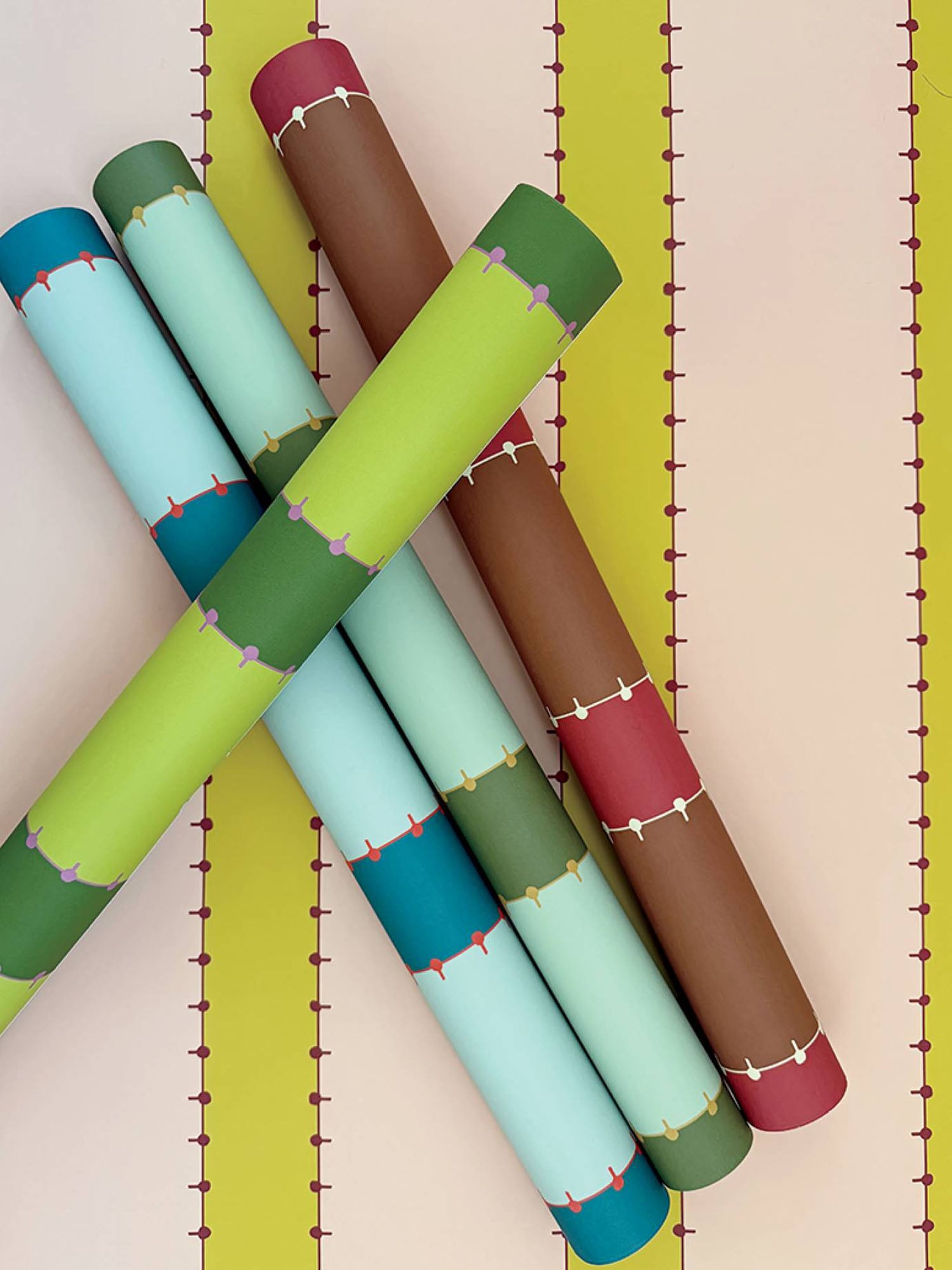 A group of four rolls of paper on a wall.