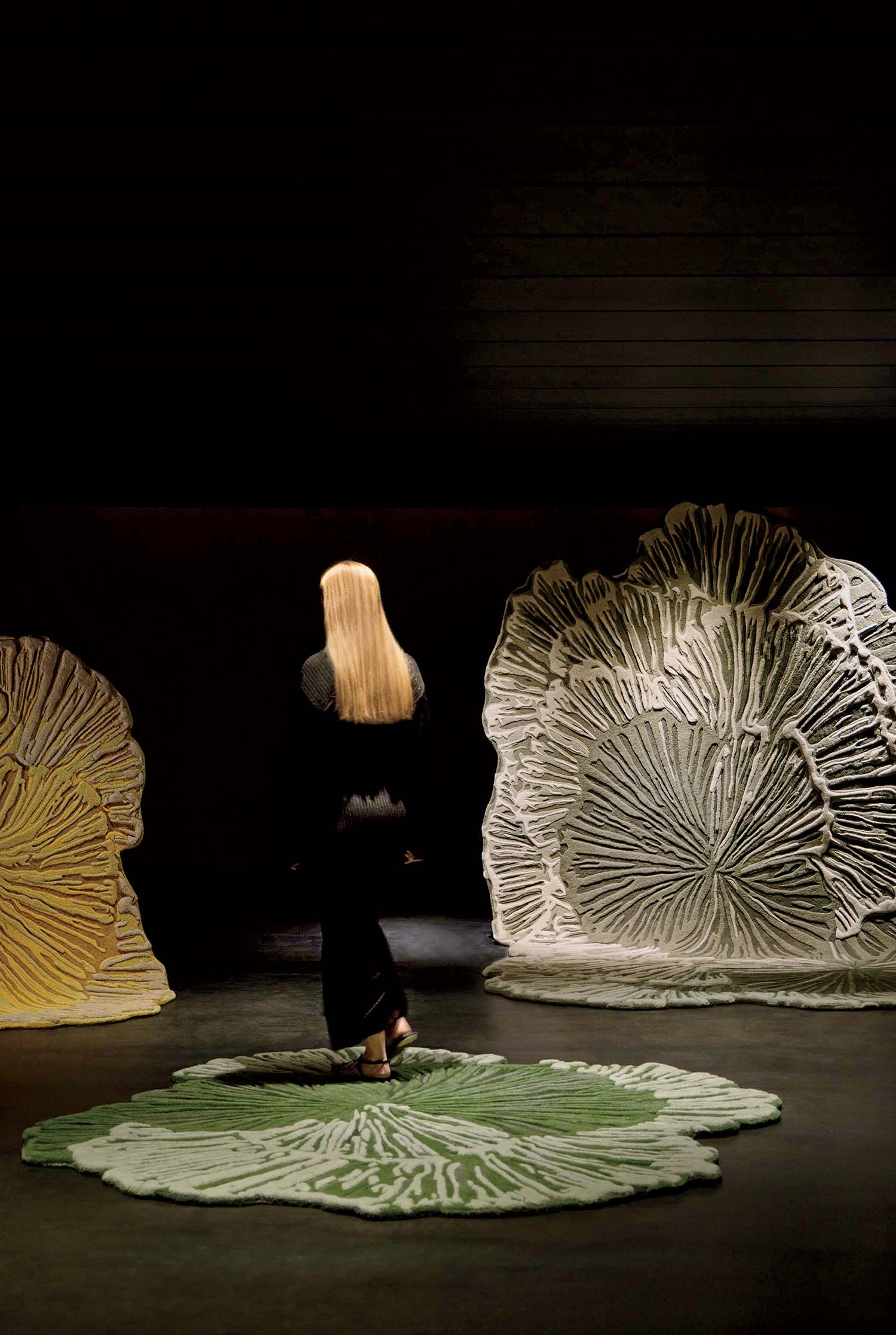A woman is standing in front of a large sculpture.