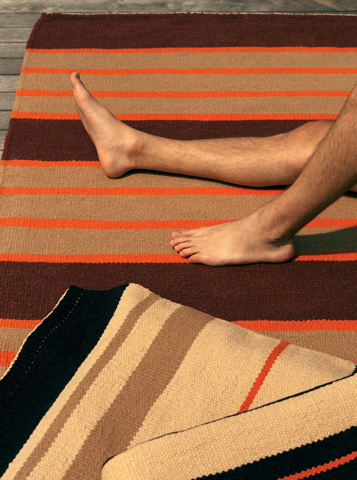 A man laying on a rug on a wooden floor.
