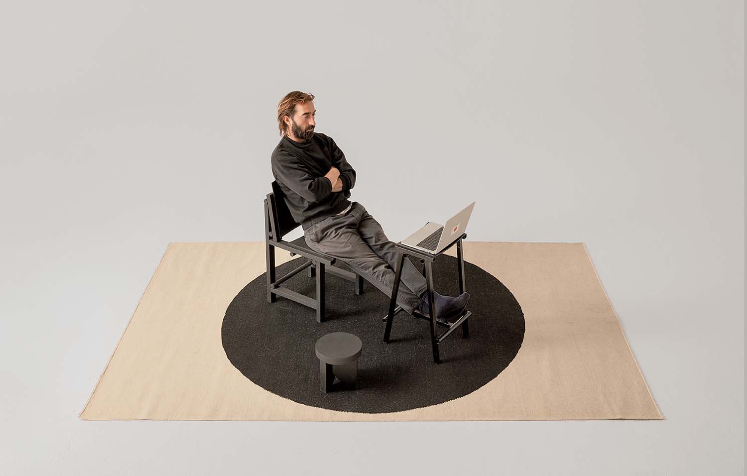 A man sitting on a chair with a laptop.