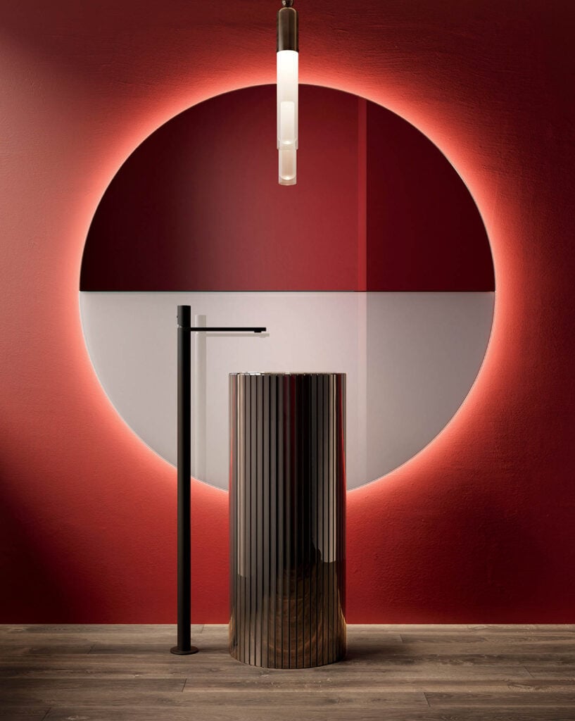 A red wall with a lamp and a table.