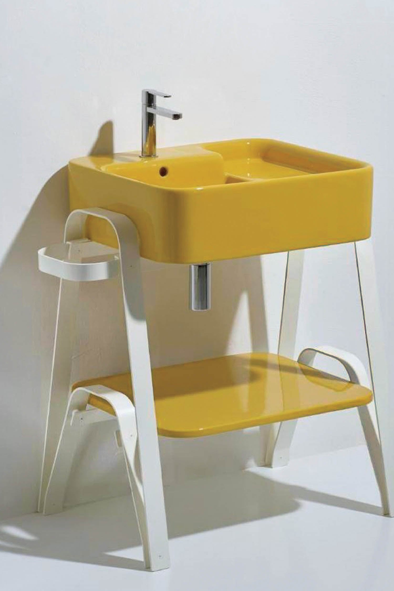 A yellow and white bathroom sink with a white chair.