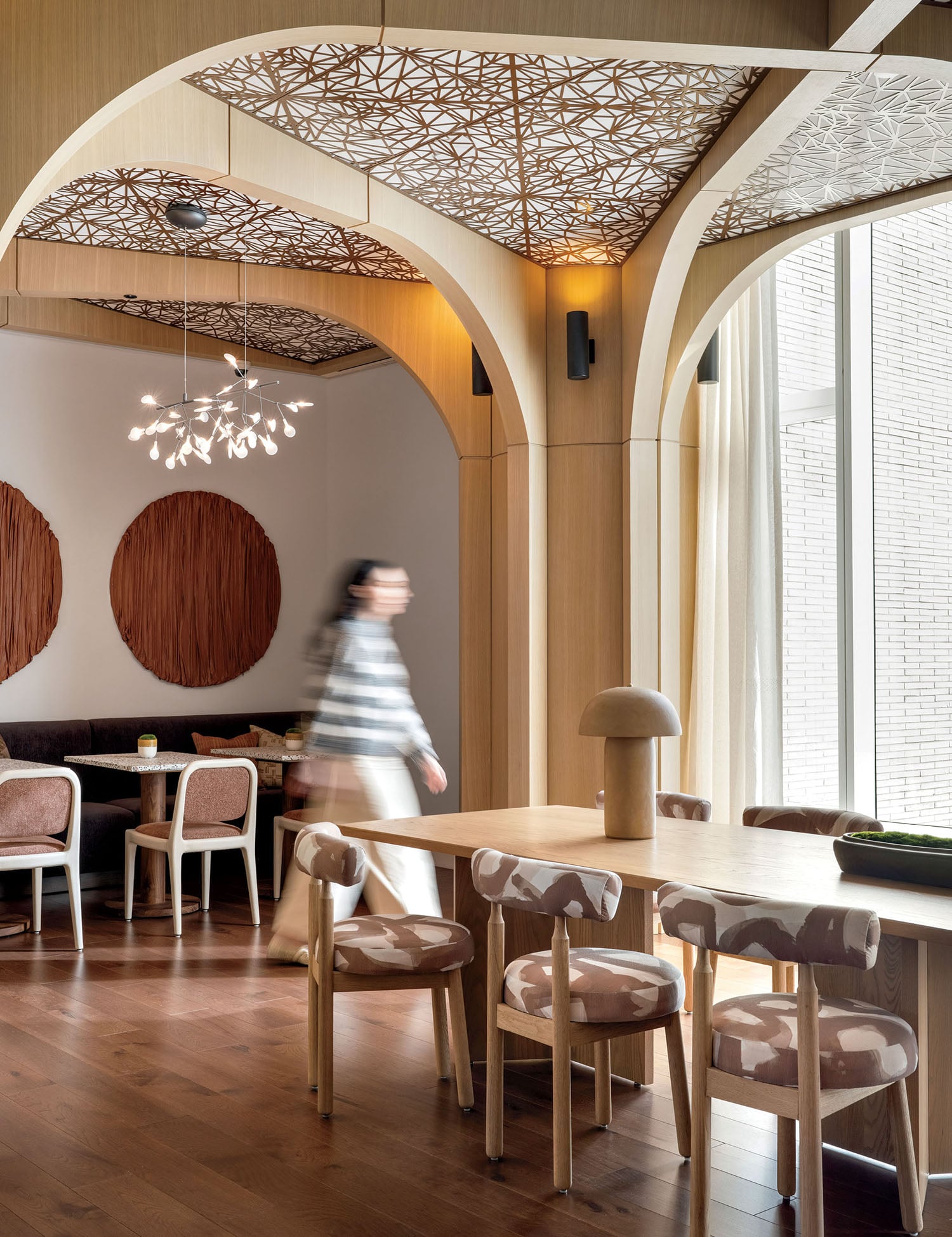 A person walking in a room with a wooden table.