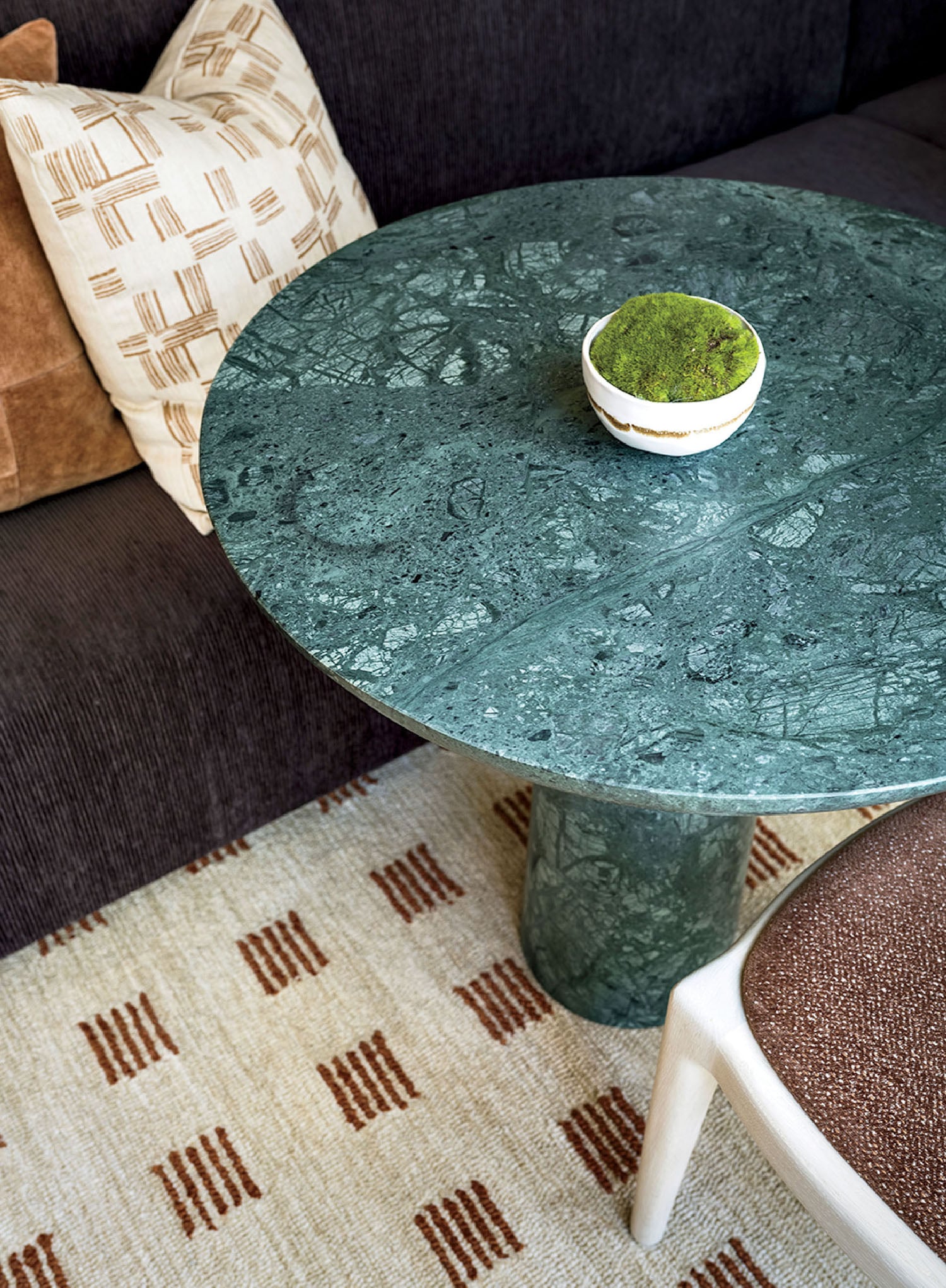 A green marble table with a bowl of green tea on it.