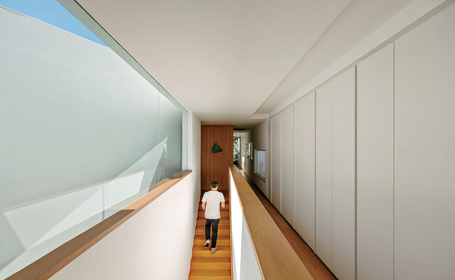 A man walking down a long hallway.