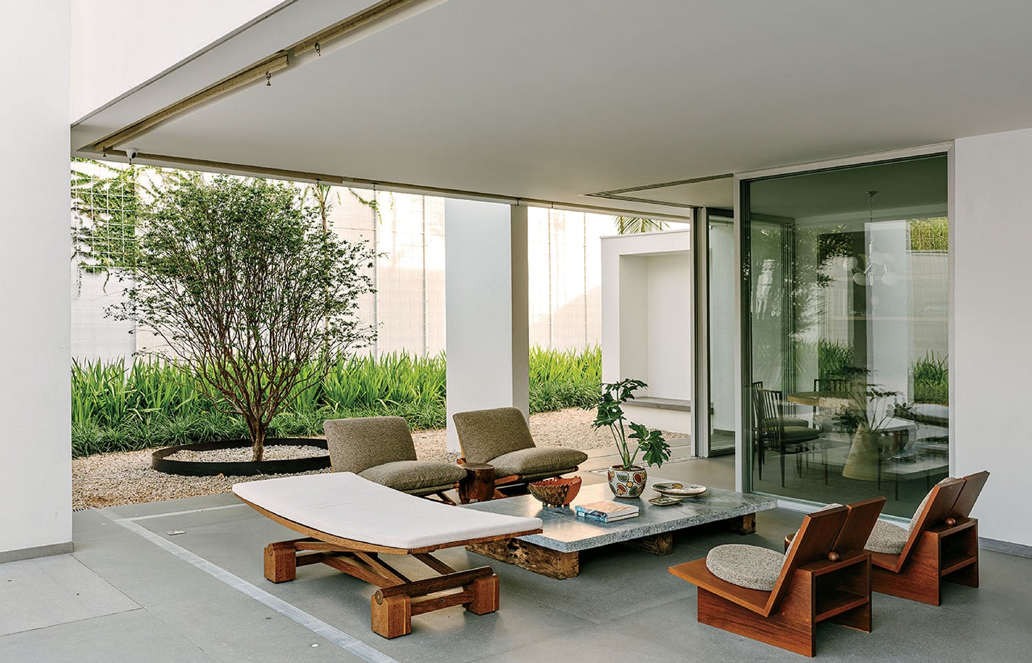 A patio with a table and chairs and a tree.