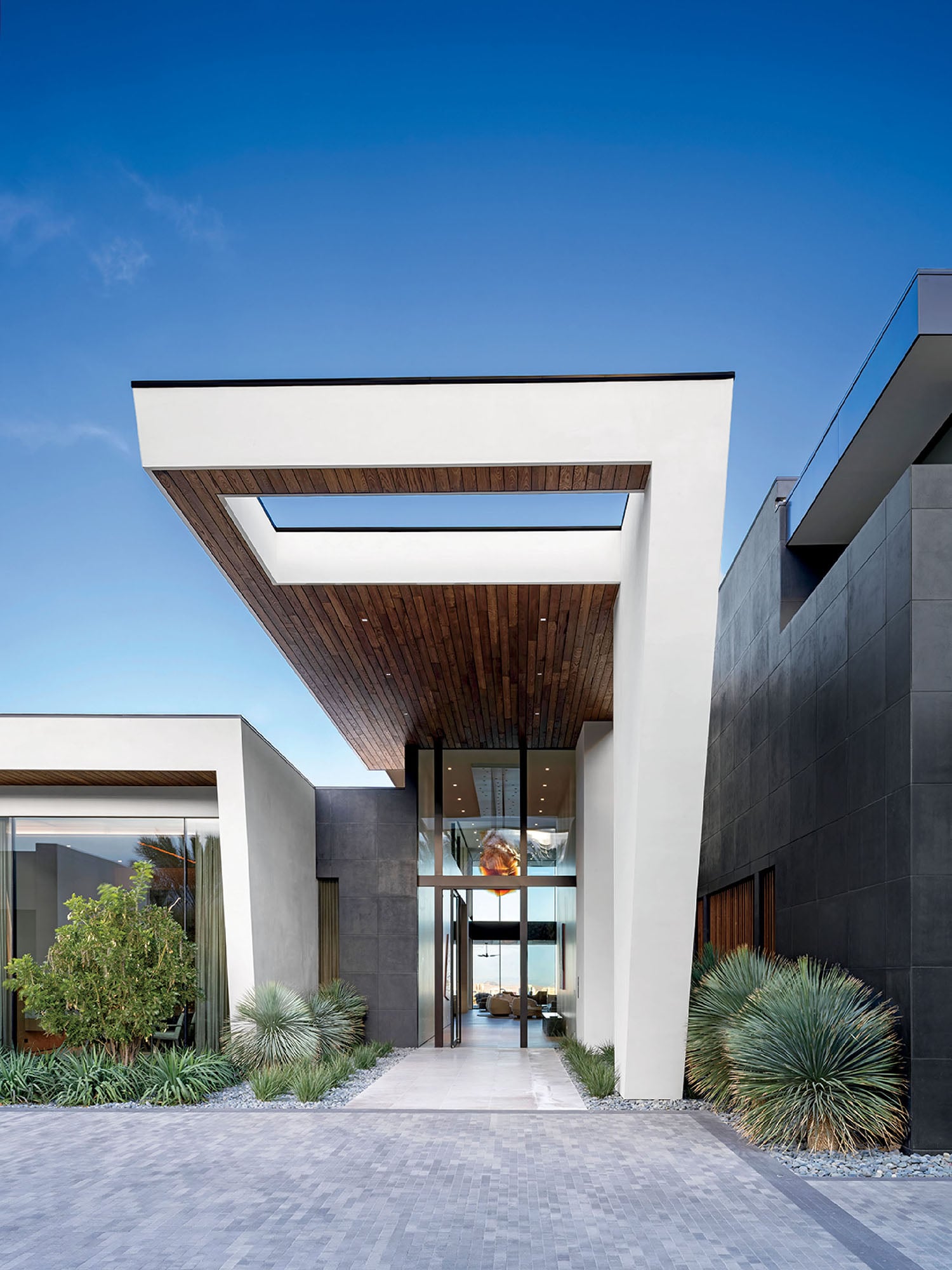 A modern house with a large driveway.