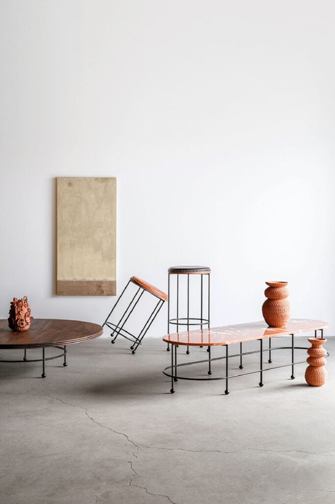 A group of three tables and a vase.