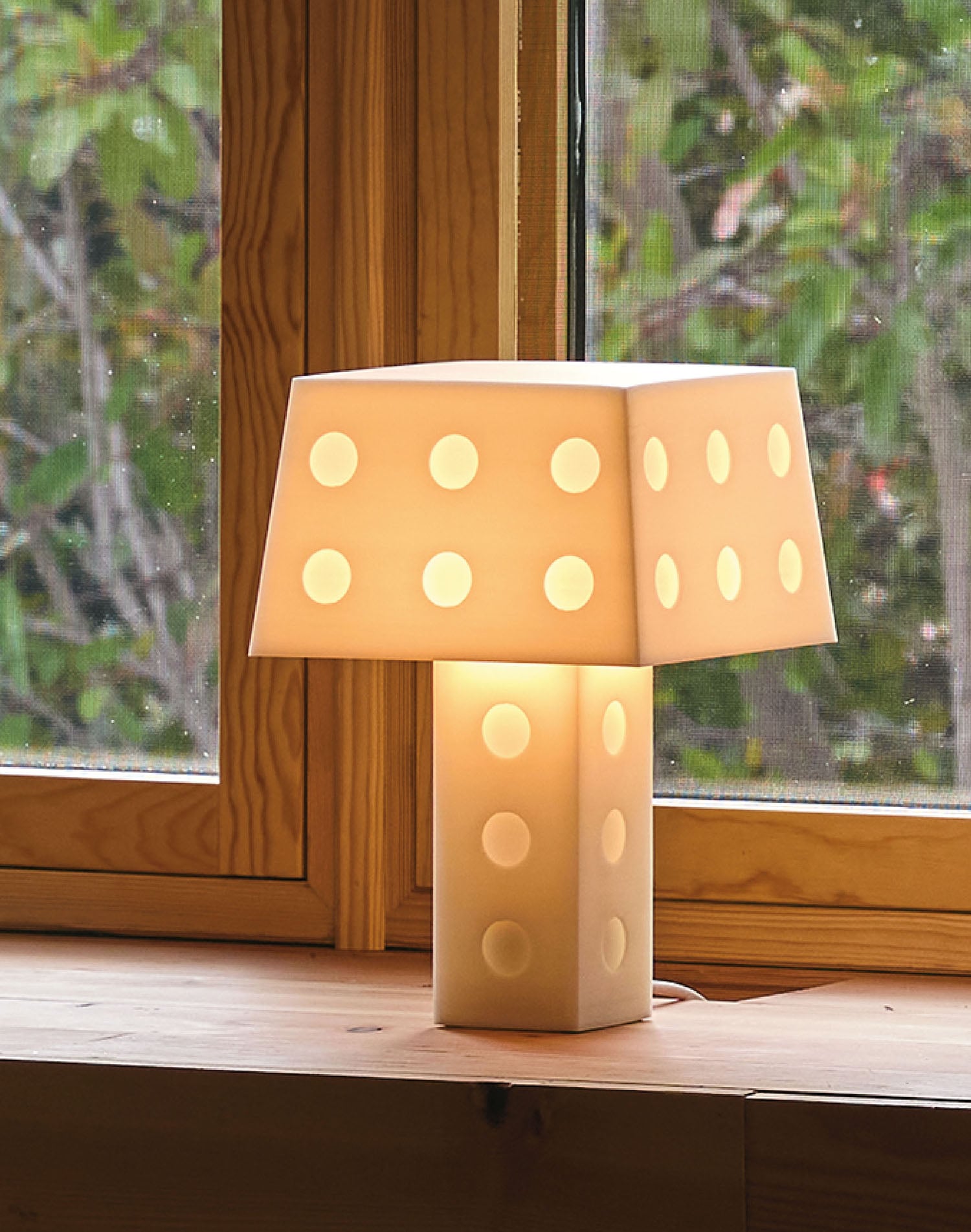 A lamp sitting on a window sie.