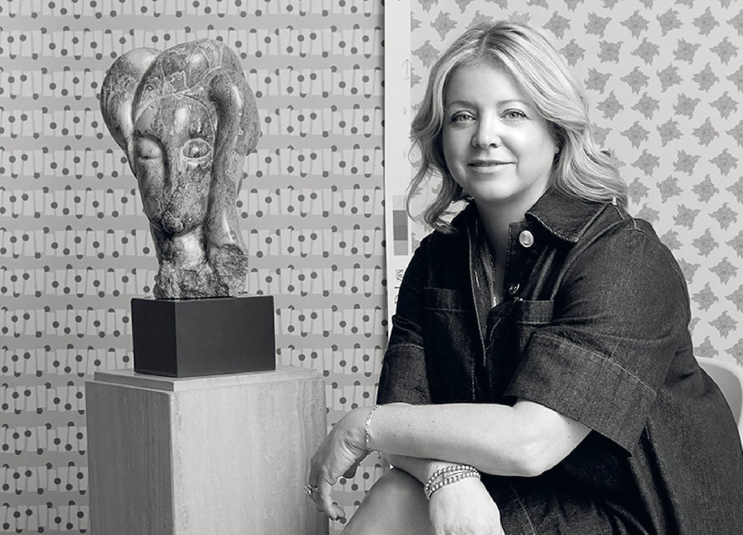 A woman sitting on a chair next to a sculpture.