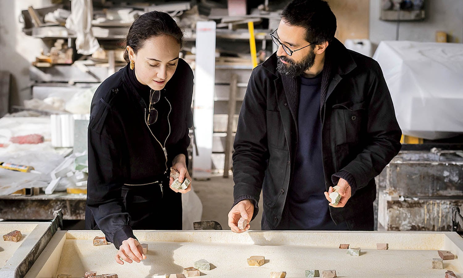 A man and woman are looking at a piece of wood.