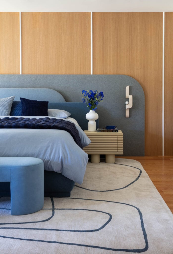 a blue headboard on wood paneled wall in bedroom