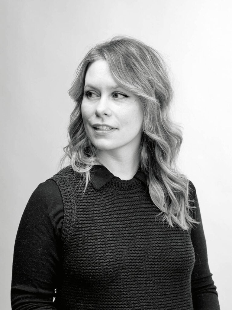 woman in black sweater with wavy blonde hair