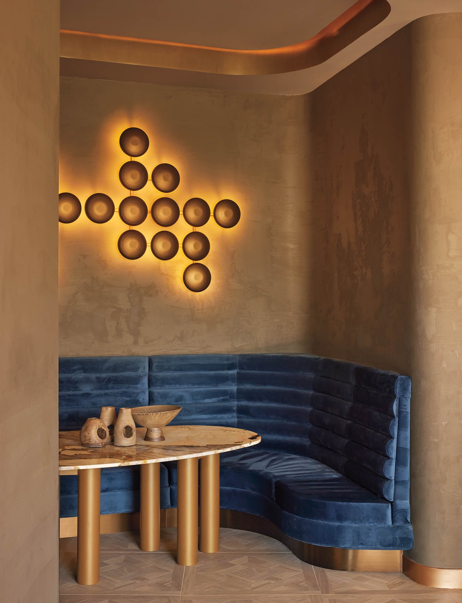 a lighting installation on a wall near blue velvet banquet