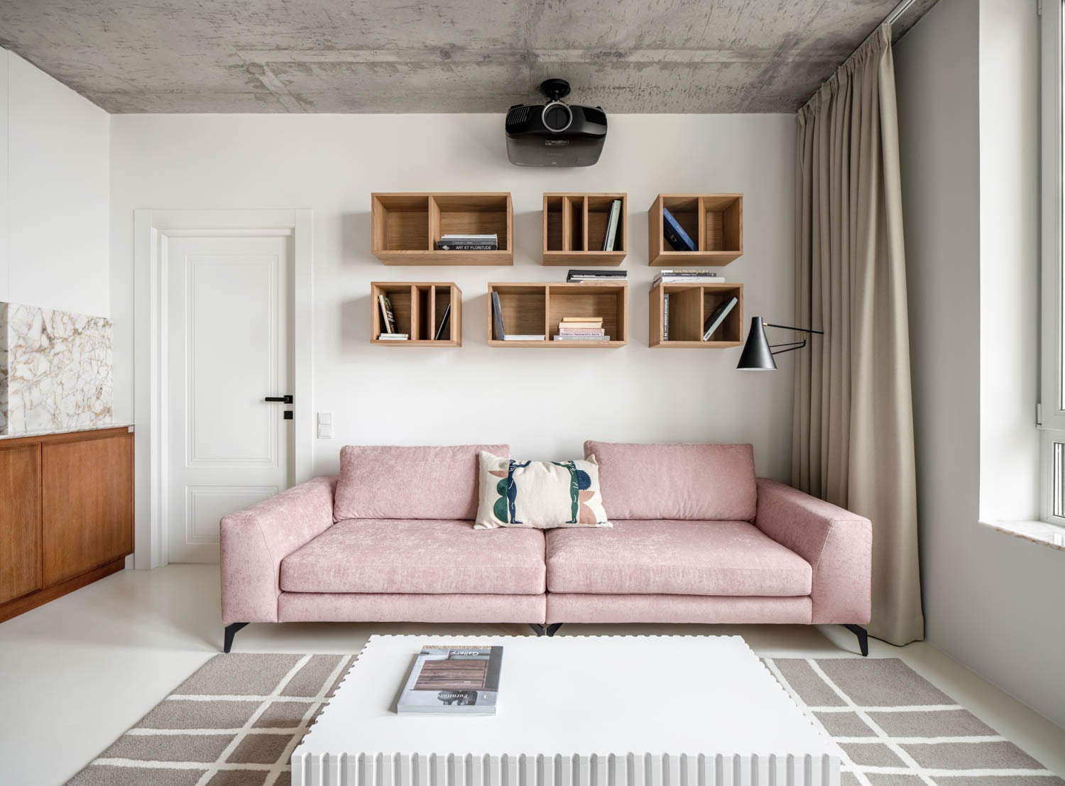 living room with rose pink couch and concrete ceiling