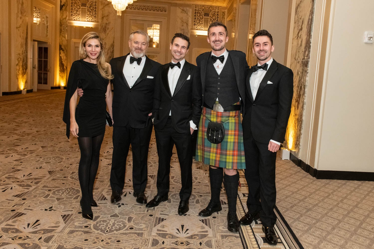 Adam Sandow posing with attendees at Waldorf Astoria ballroom