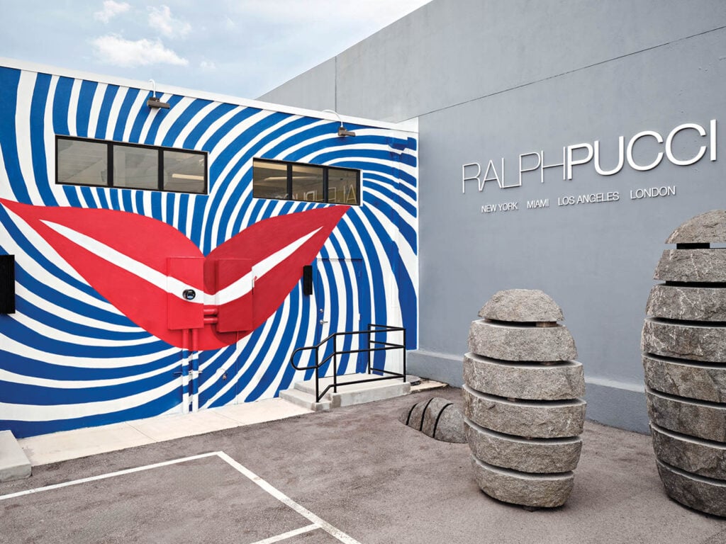 a wall mural with blue spiral shape and lips at center