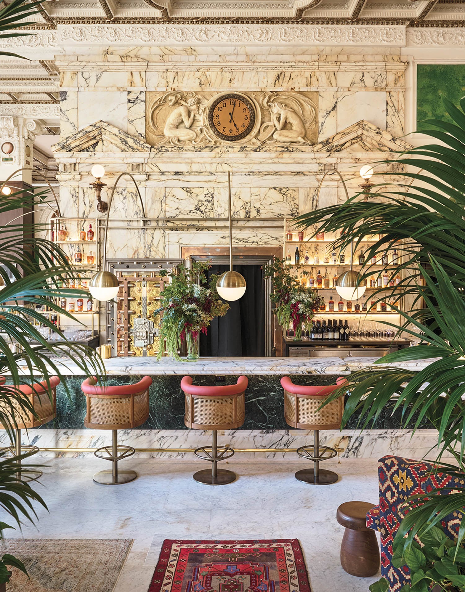 bar stools near ornate wall with greenery