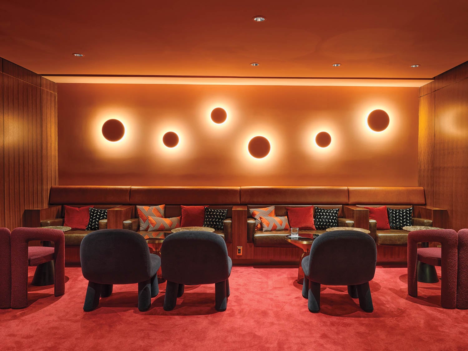 a circular illuminated wall installation near lounge seating