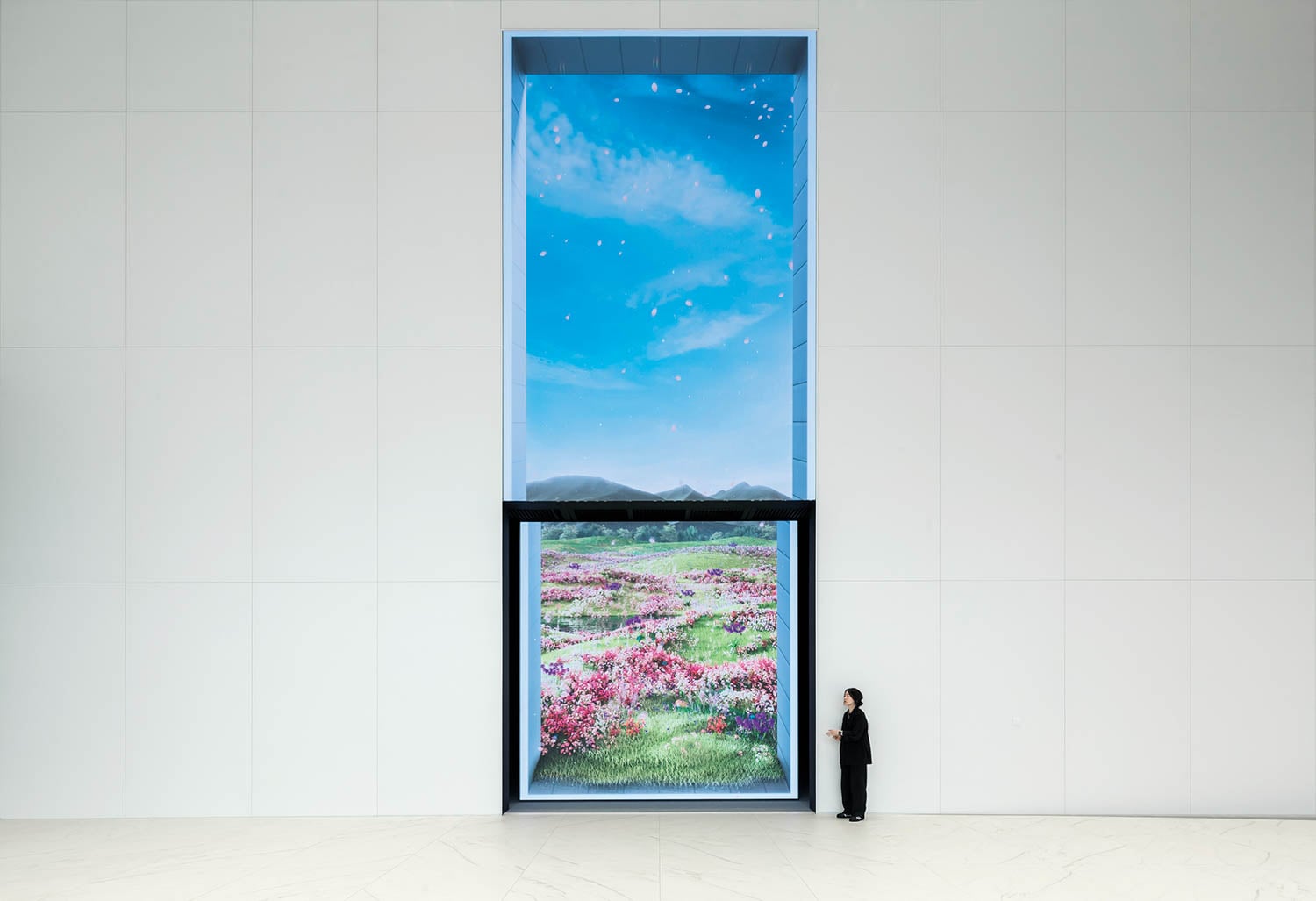 a person next to a large painting on white wall