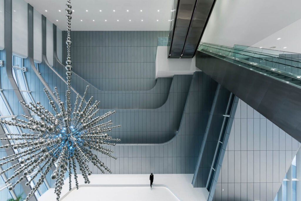 a person standing near a giant snowflake installation