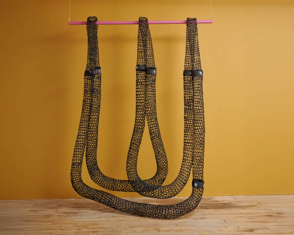 black ropes hanging from a yellow bar