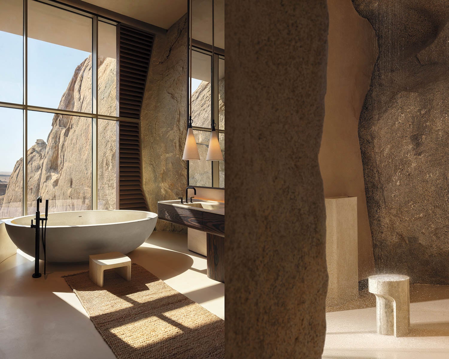 Luxurious bathroom with an oval stone bathtub, rustic rock walls, and large windows showing a natural rocky landscape