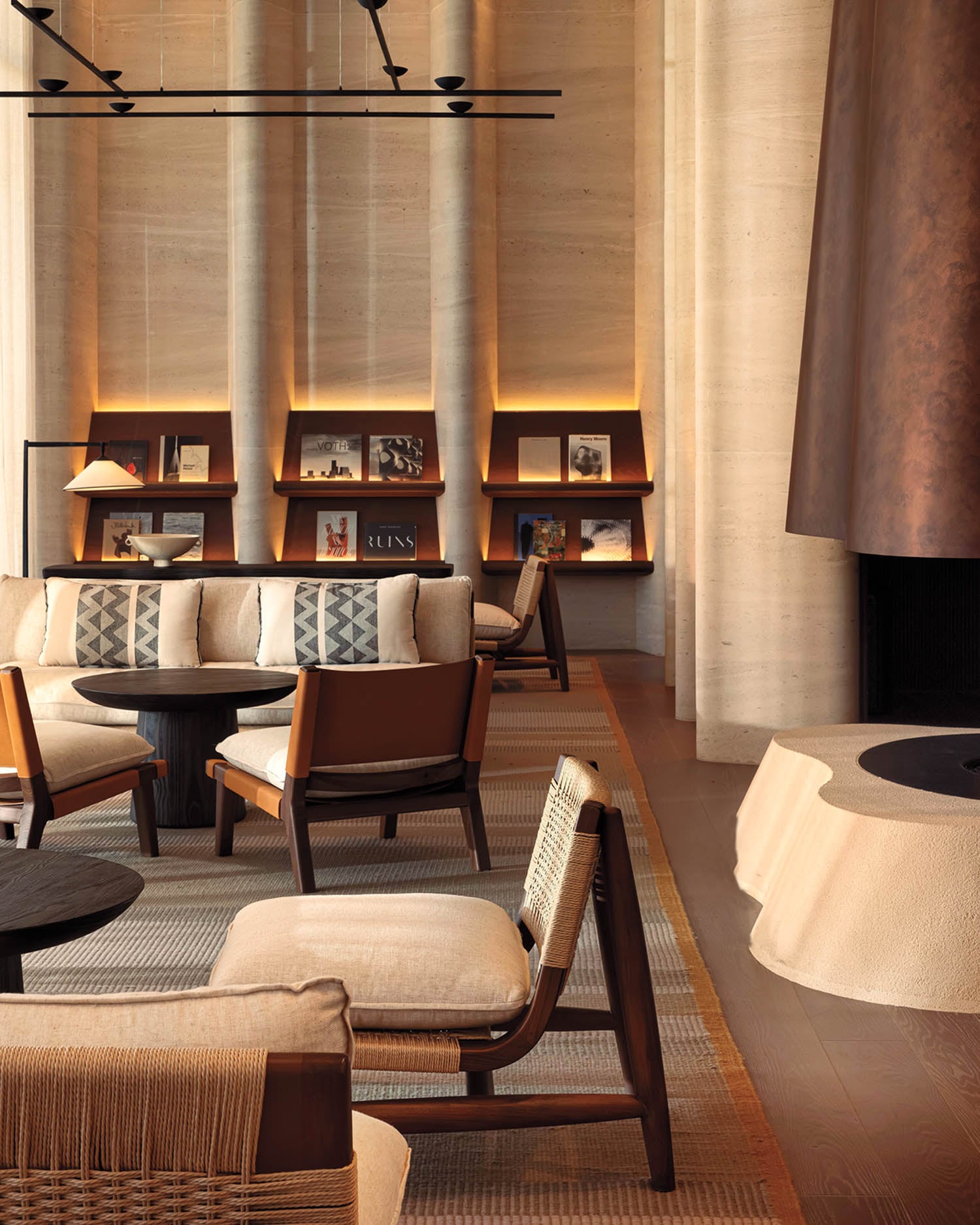 Sophisticated lounge with plush seating, earth-toned decor, and a modern fireplace