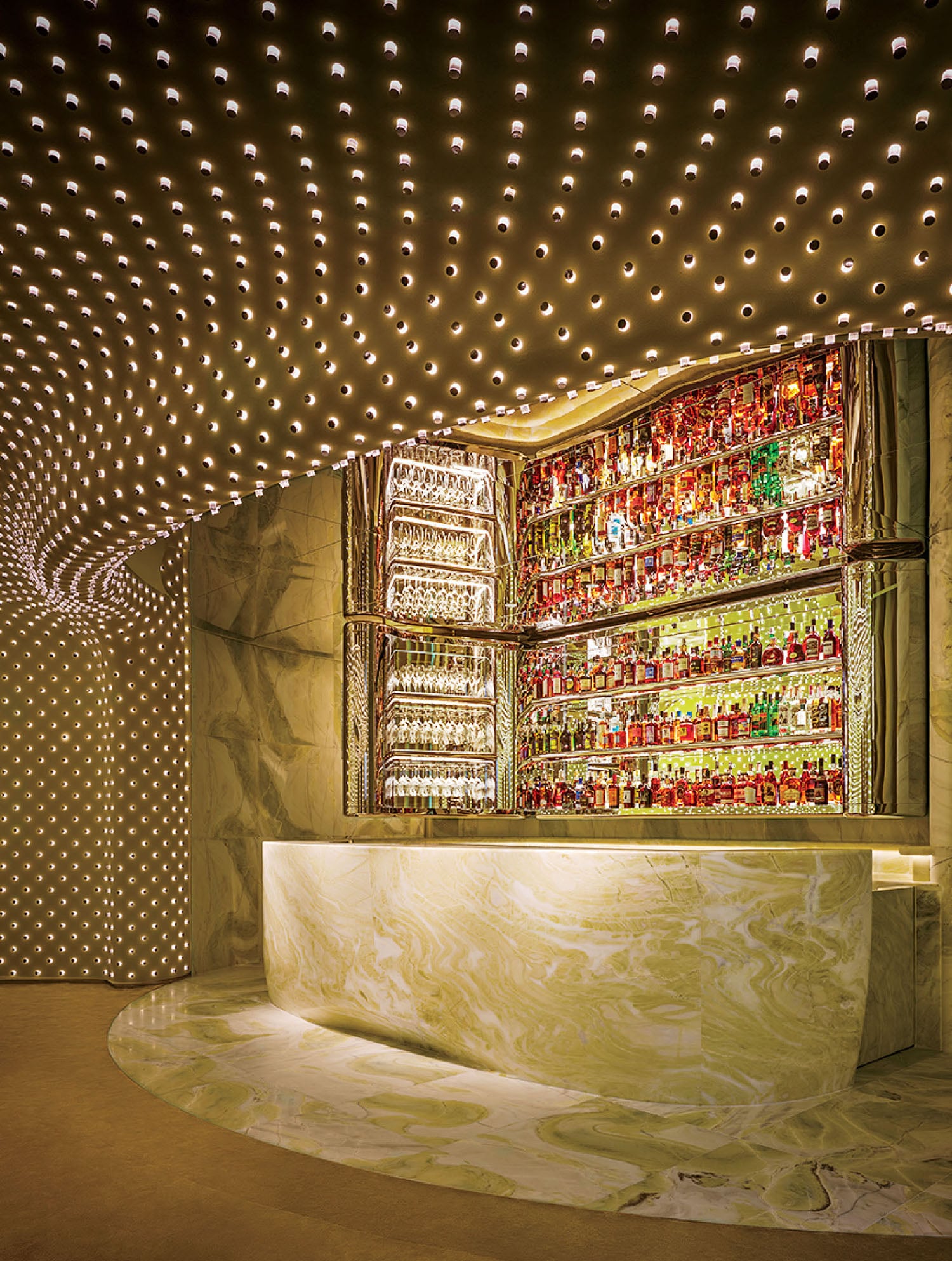 A bar with a lot of bottles on the wall.