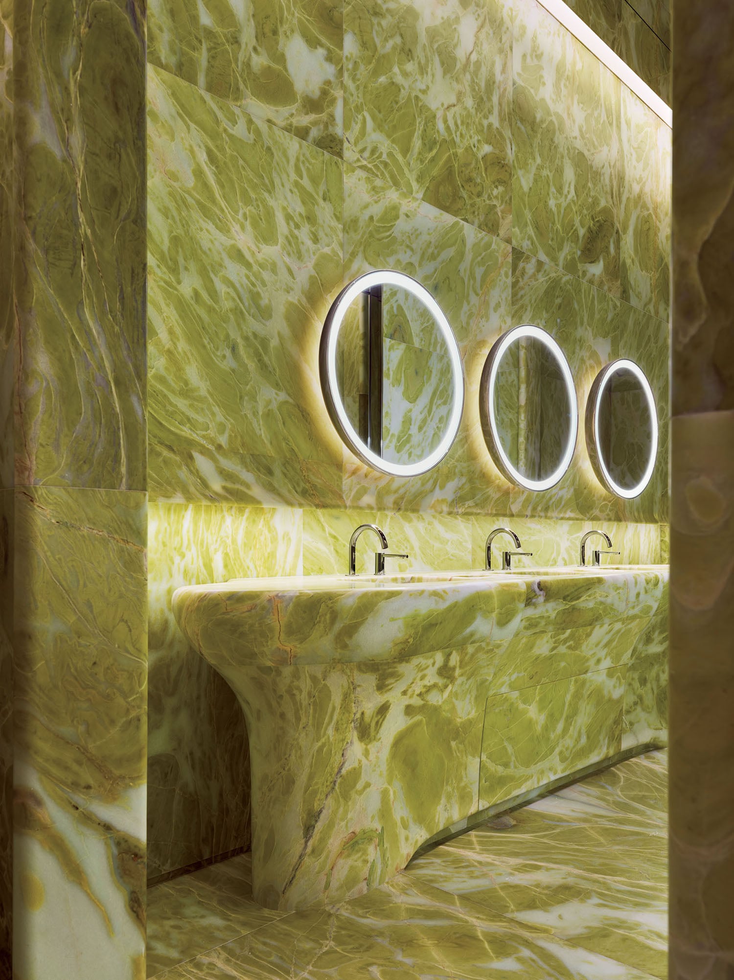 A bathroom with a marble wall and a sink.