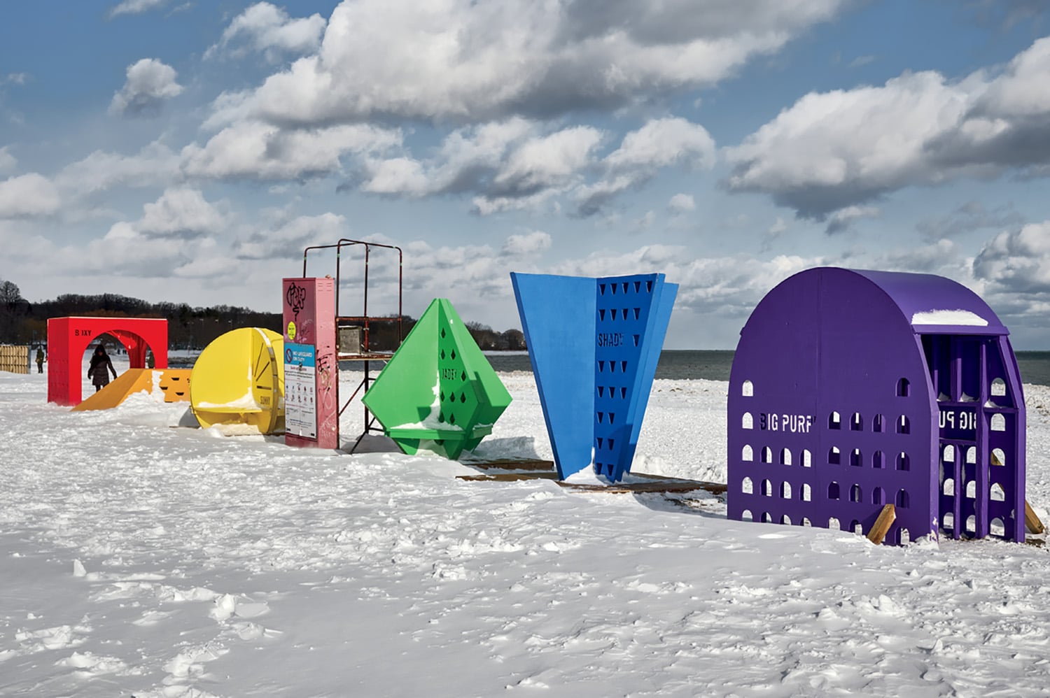 A row of colorfully painted letters on a snowy surface.