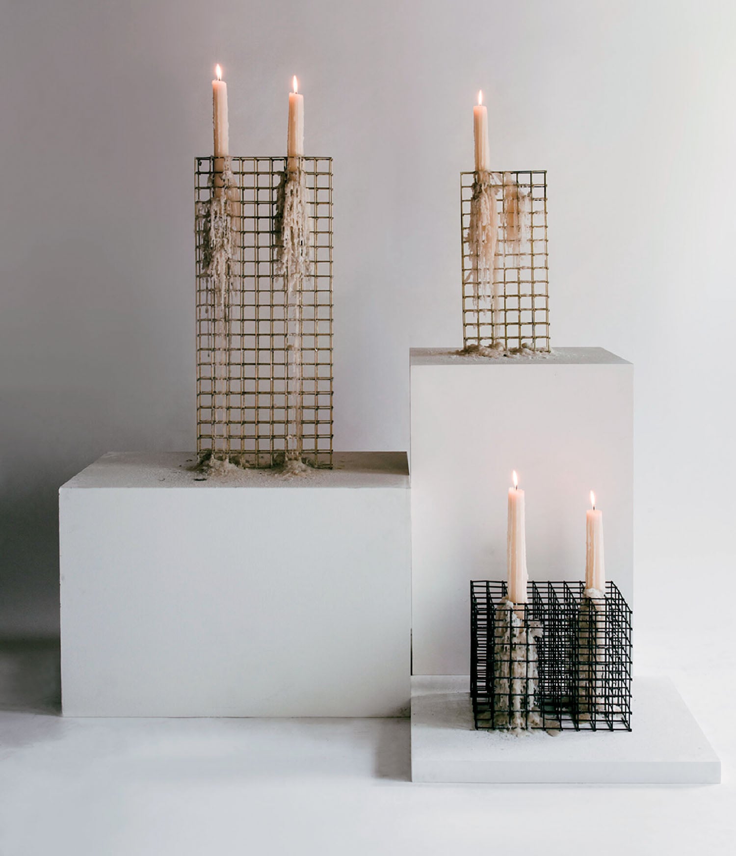 Two candles on a white pedestal with a black and white box.
