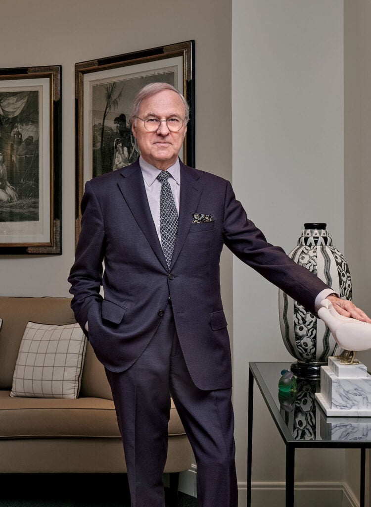 A man in a suit and tie standing in a living room.