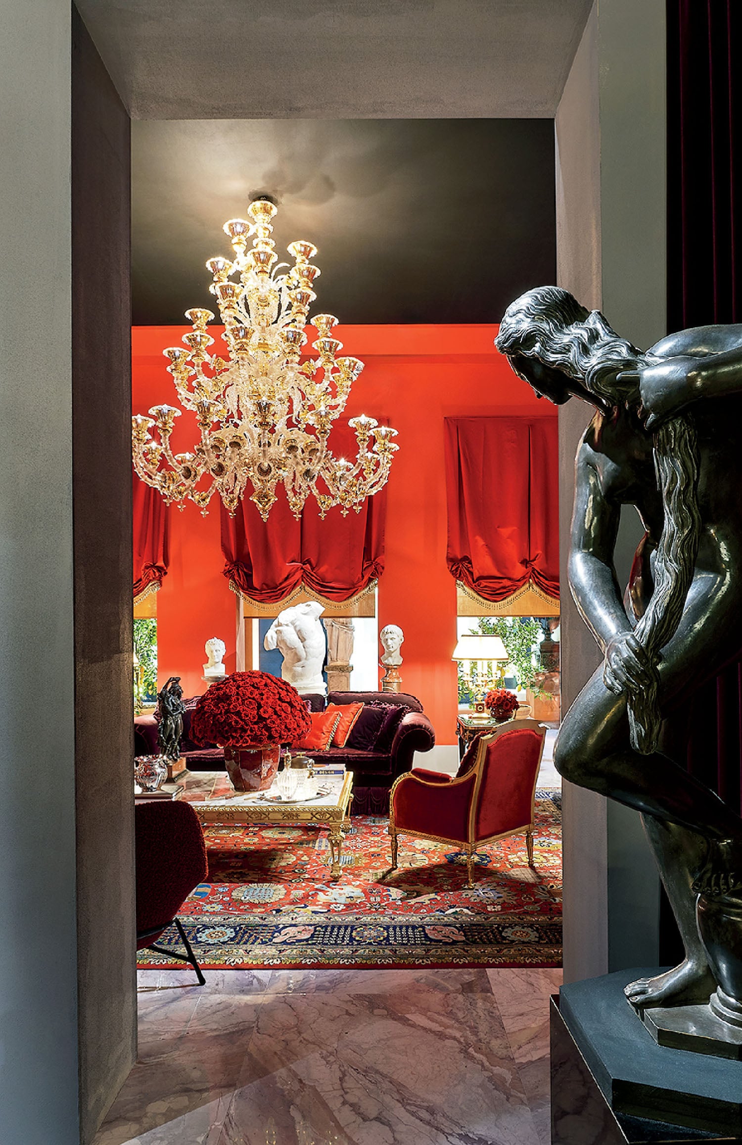 A living room with a large mirror and a sculpture.