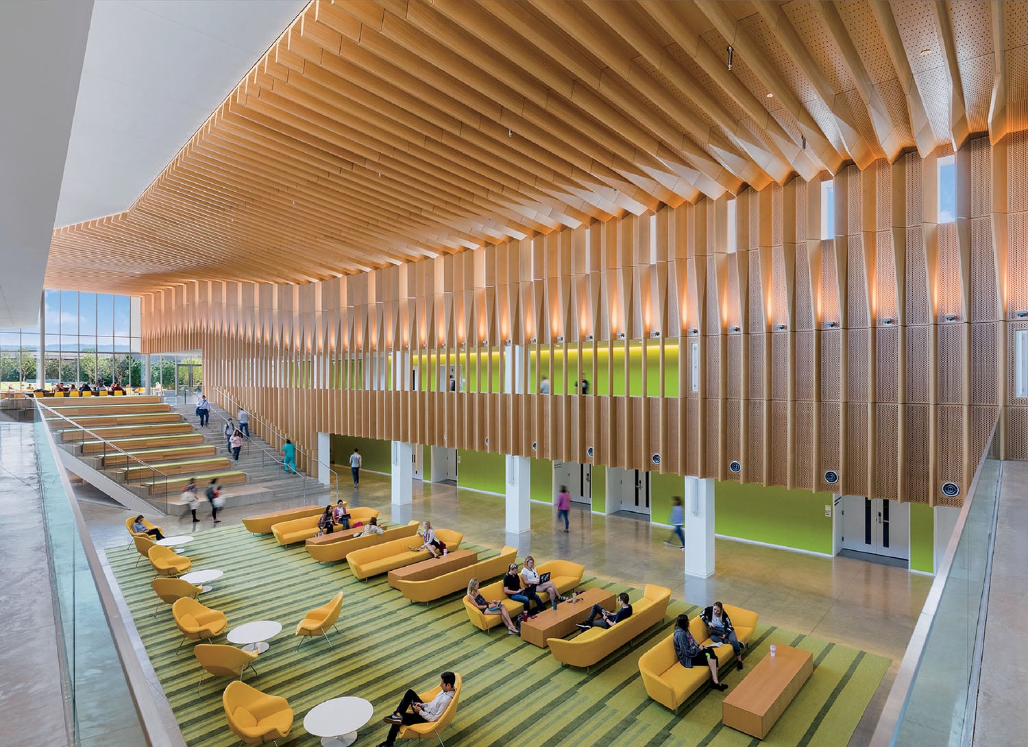 A large room with a lot of people sitting on couches.