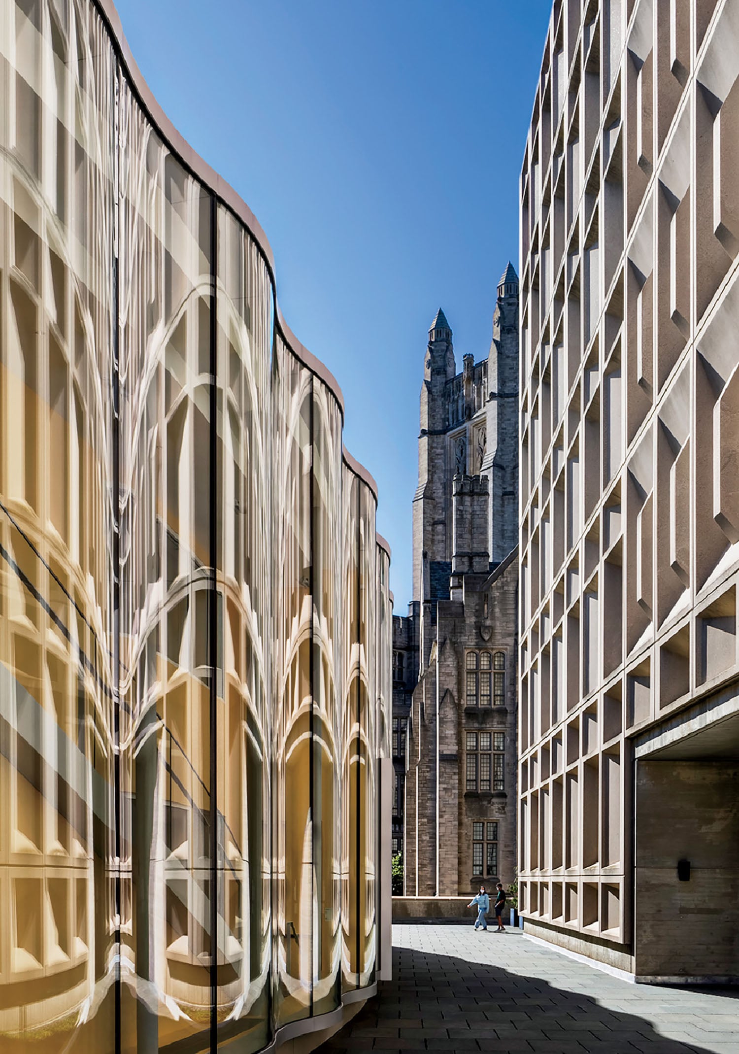 A building with a large window and a clock tower in the background.