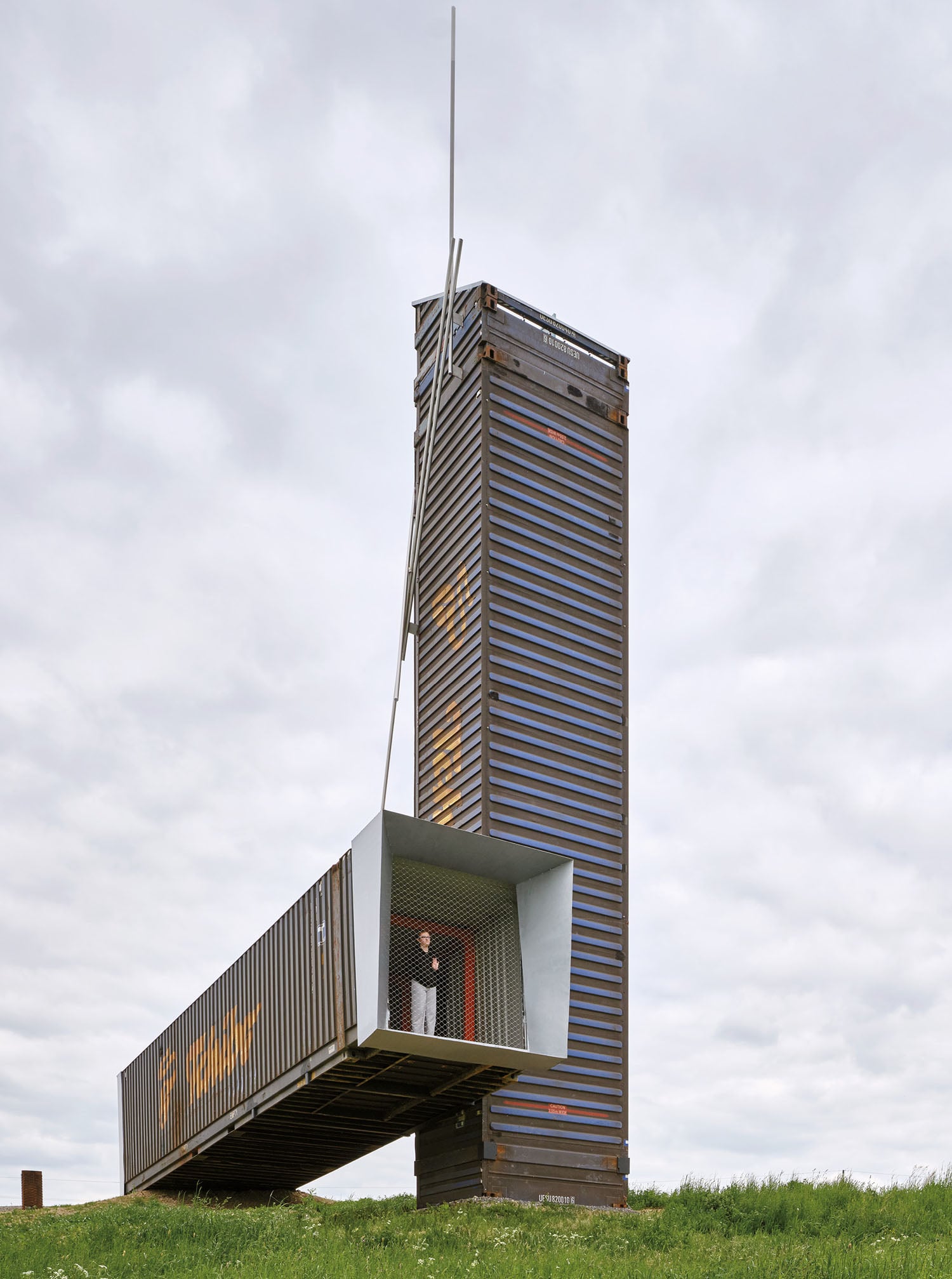 A tall building with a man standing on top of it.
