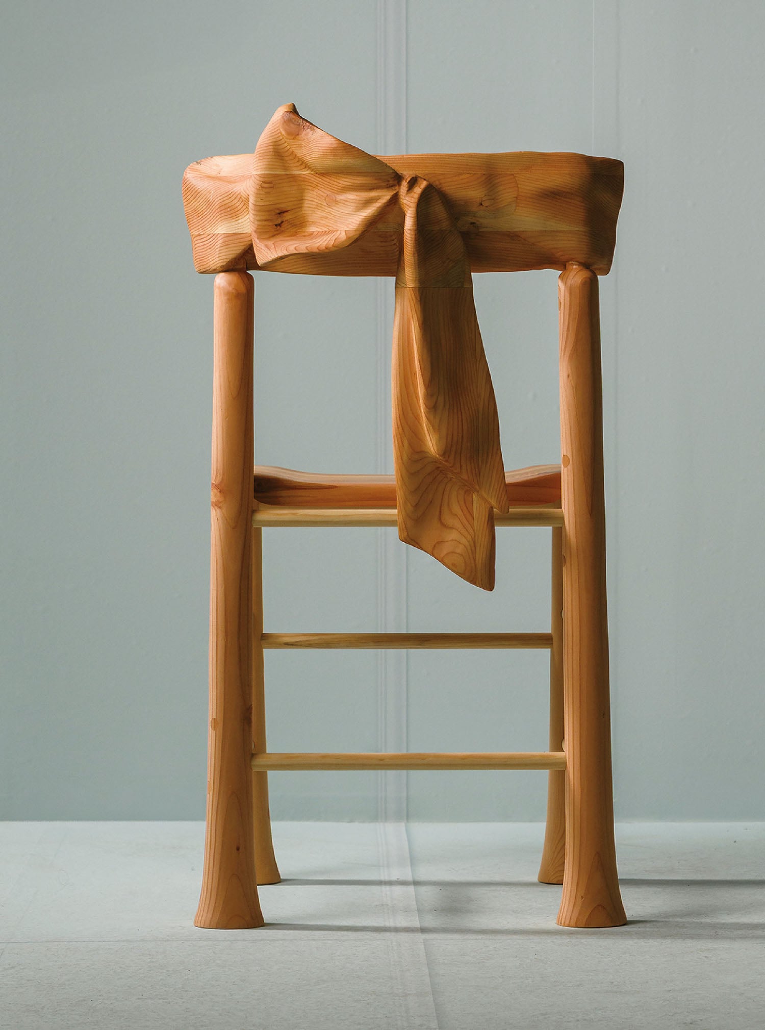 A wooden chair with a bow on it.