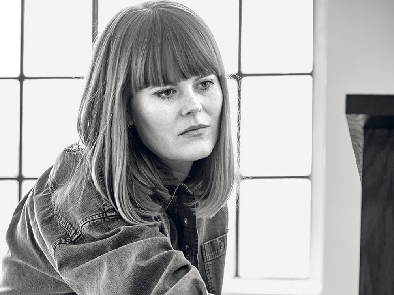A woman sitting on a chair with a laptop.