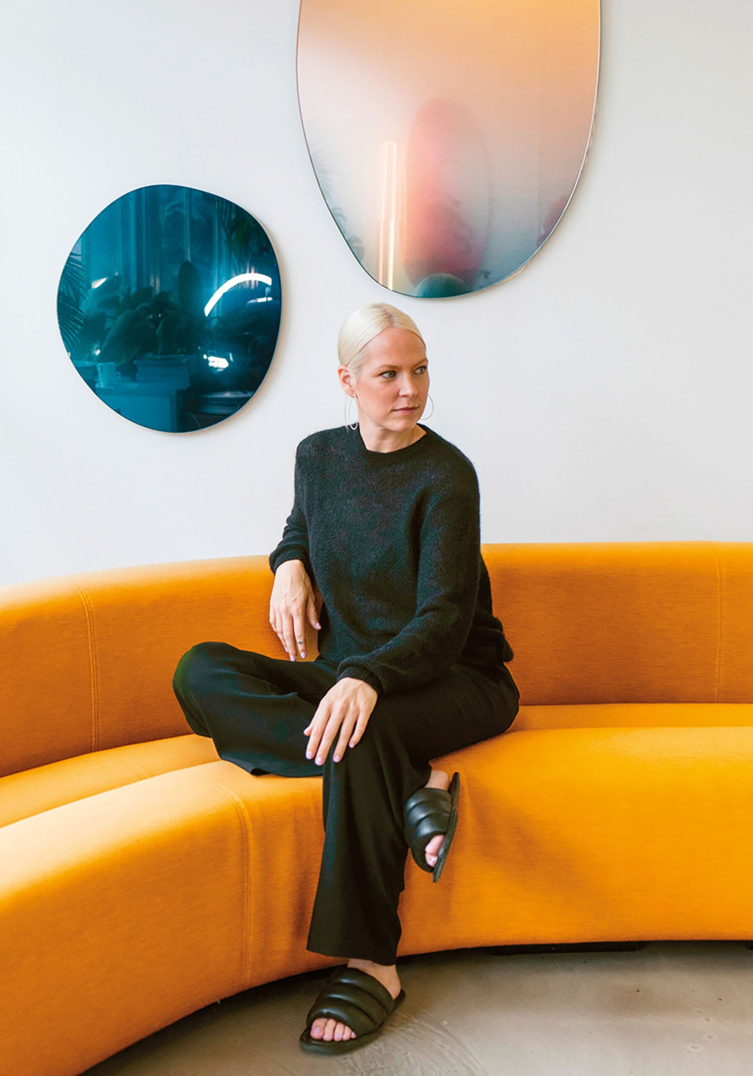 A woman sitting on a couch in a room.