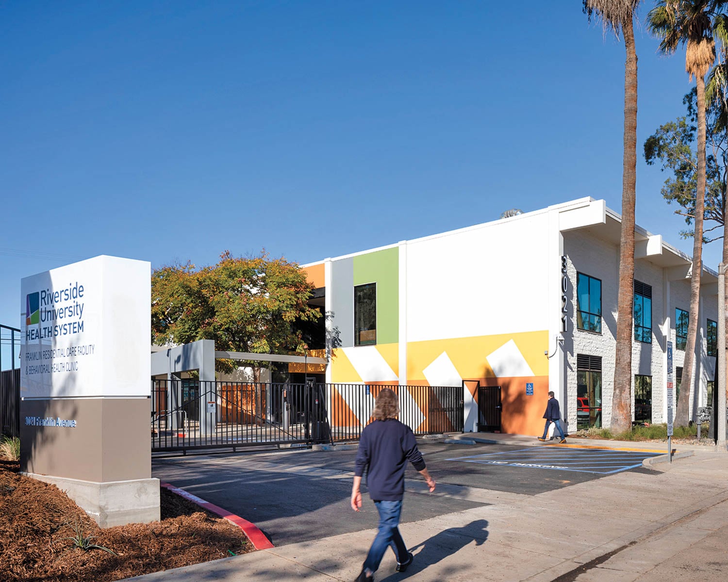 Modern building of Riverside University Health System, with colorful geometric patterns, palm trees