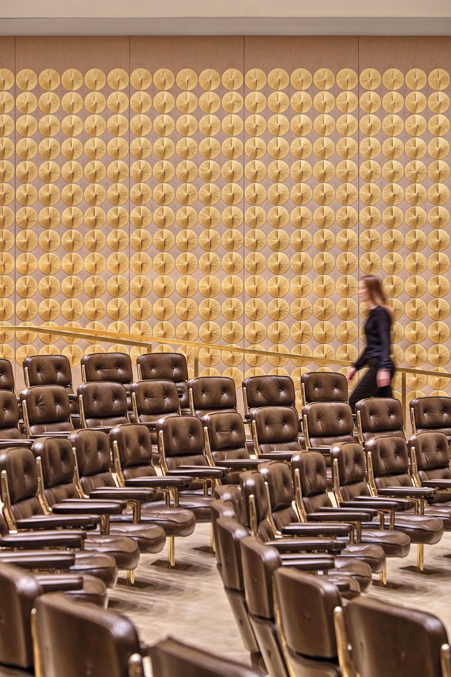 girl walking up the stairs with brown chairs
