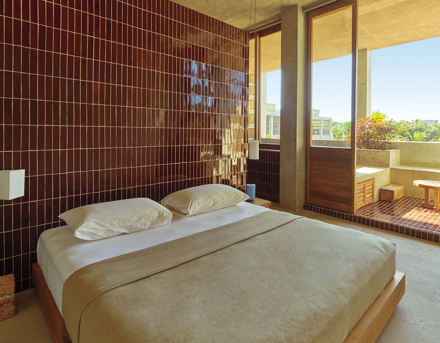 A serene bedroom with a minimalist design features a bed with white linens