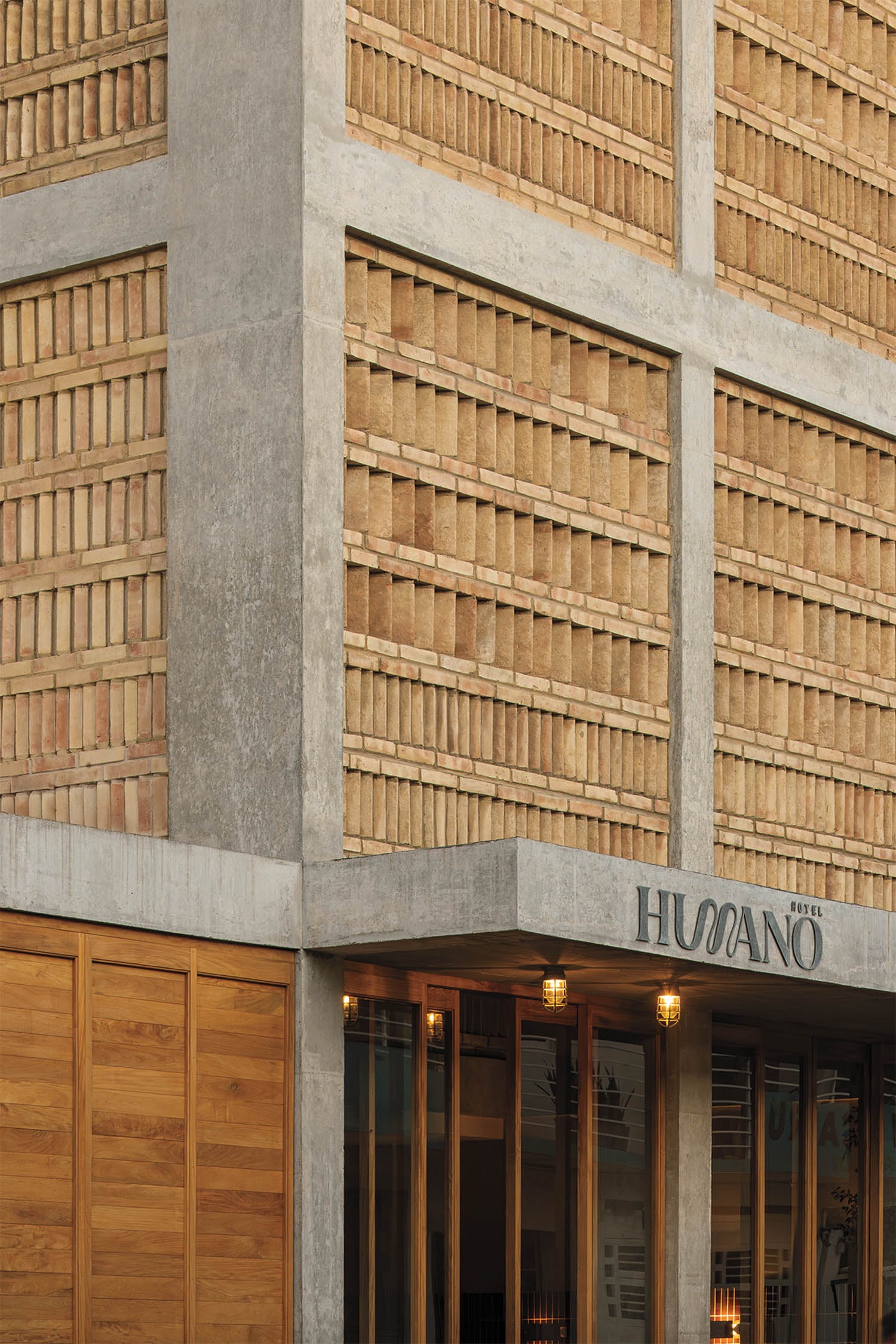 Brick and concrete facade of a modern building with "Humano" sign