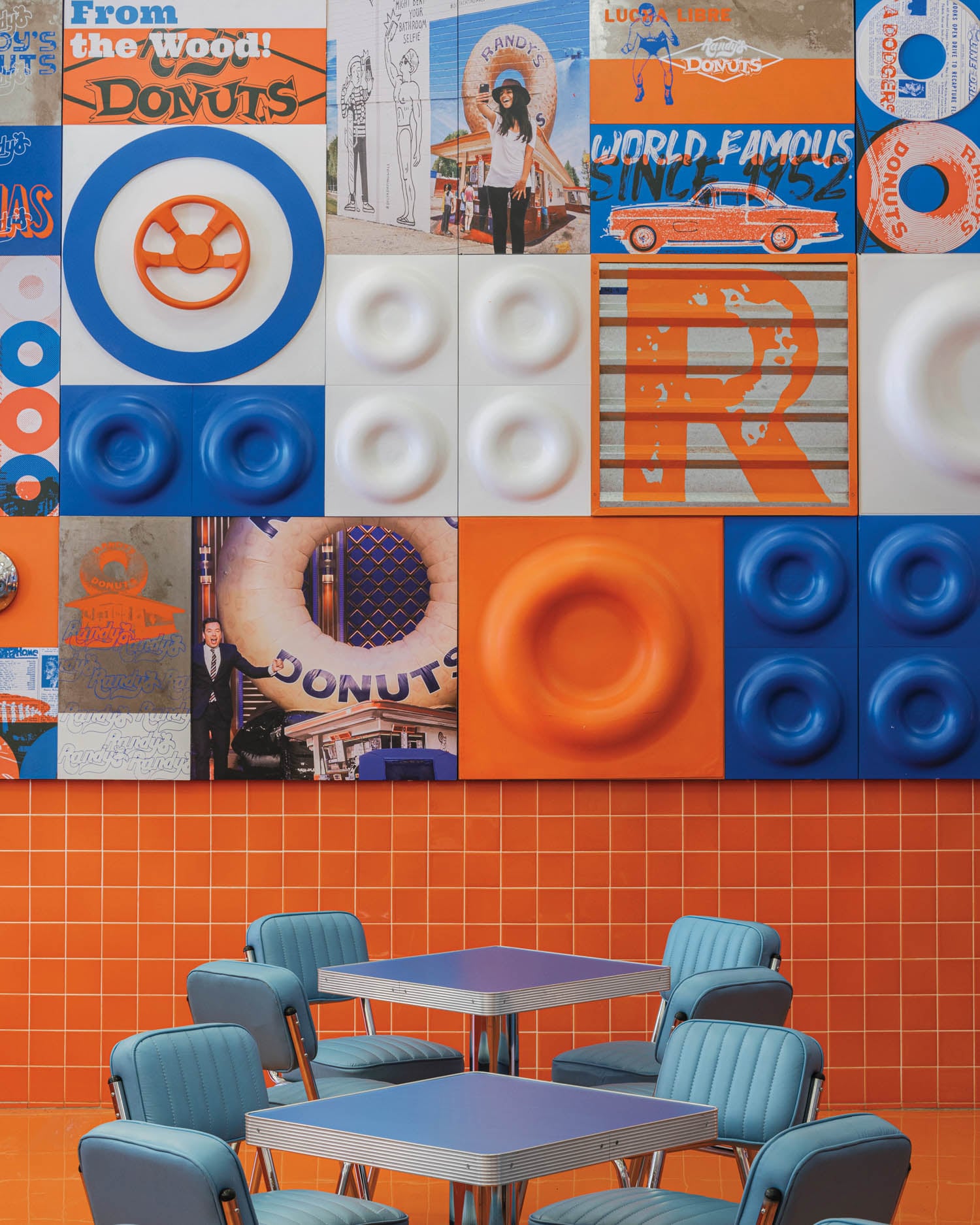 A vibrant wall of colorful donut-themed art with orange, blue, and white tiles
